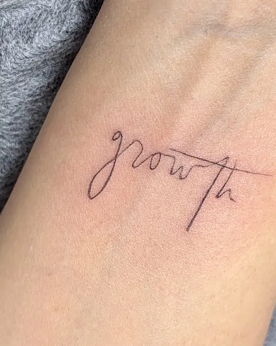 Schriftzug „growth“ über dem Handgelenk